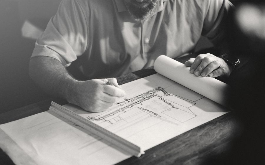 Progettista che disegna un progetto sul tavolo da lavoro